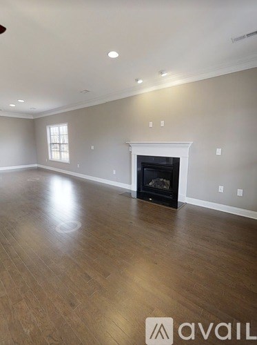 A spacious living room with a fireplace and hardwood floors.