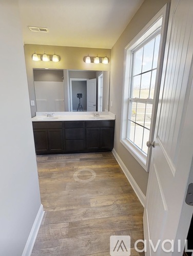 A bathroom with a large mirror and a vanity.
