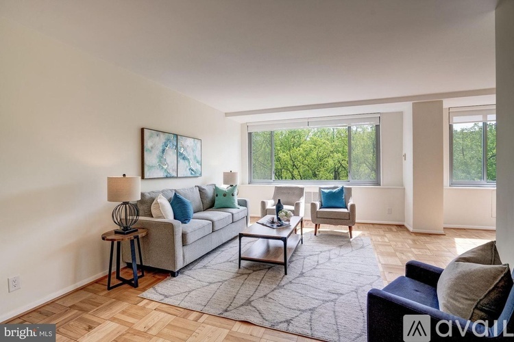 A living room with a grey couch, a coffee table, and a painting on the wall.
