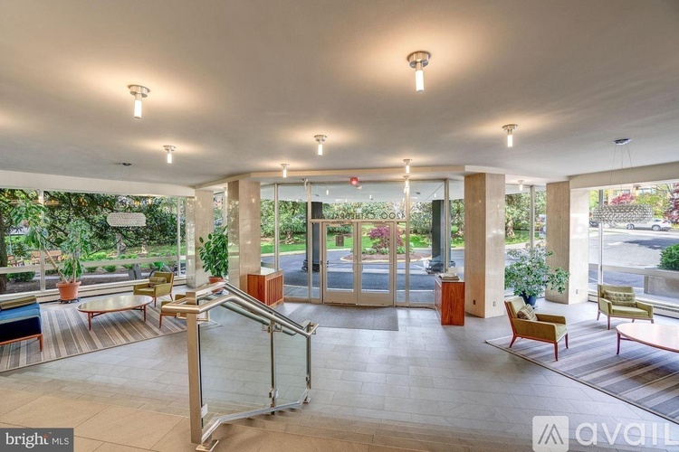 A spacious lobby with a glass door entrance and a staircase.