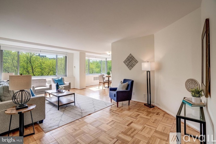 A living room with a blue chair and a wooden floor.