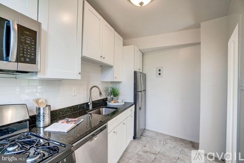 A kitchen with white cabinets and a black stove top.