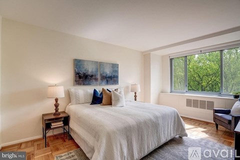 A bedroom with a large bed and a painting on the wall.