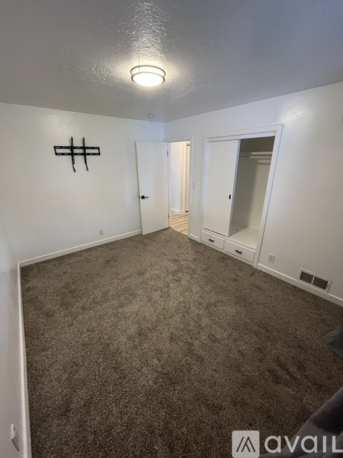 A room with a carpeted floor and a wall-mounted light fixture.