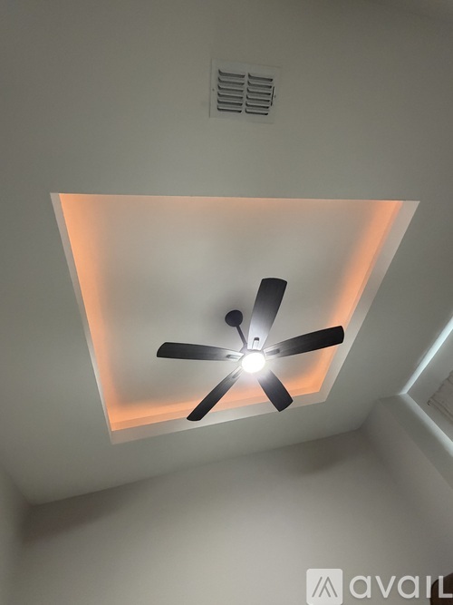 A ceiling fan with a light on in a room.