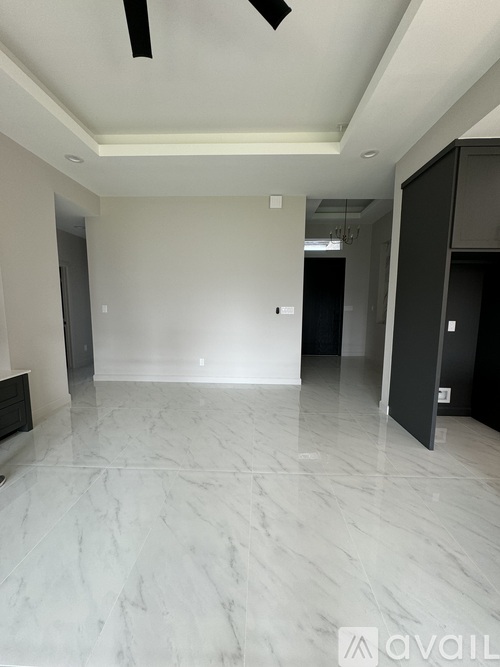 A spacious room with marble flooring and a ceiling fan.