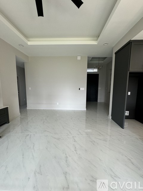 A spacious room with marble flooring and a ceiling fan.