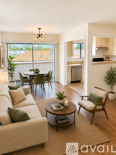 A living room with a couch, chairs, and a table with a plant on it.