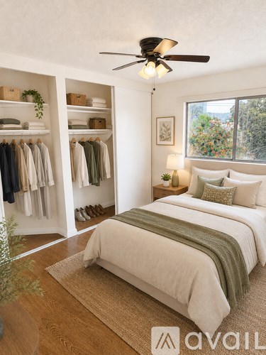 A bedroom with a bed, a ceiling fan, and a wardrobe with clothes hanging.