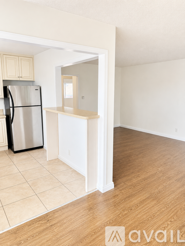 A kitchen with a refrigerator and a white cabinet.