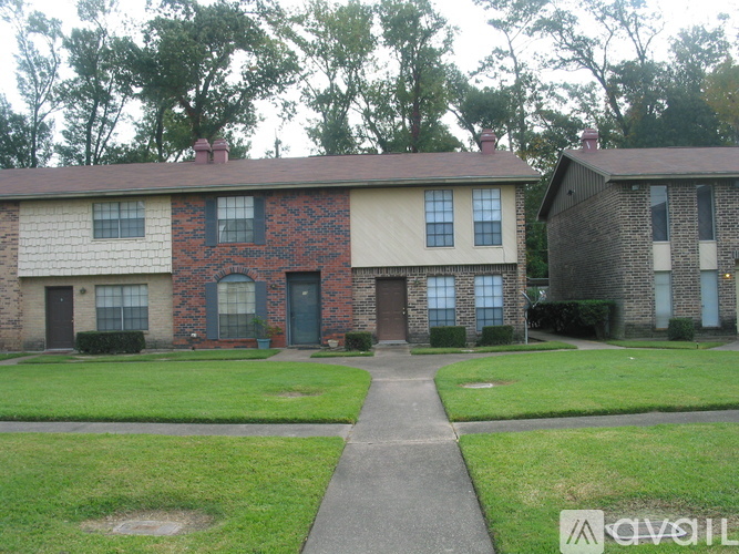 A brick house with a green door and a brown door.