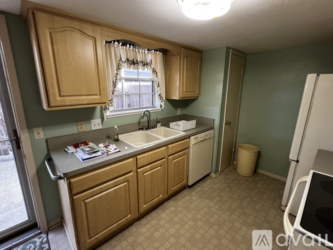 A kitchen with green walls and wooden cabinets.
