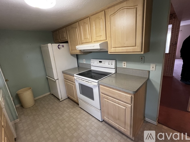 A kitchen with a white refrigerator, stove, and oven.