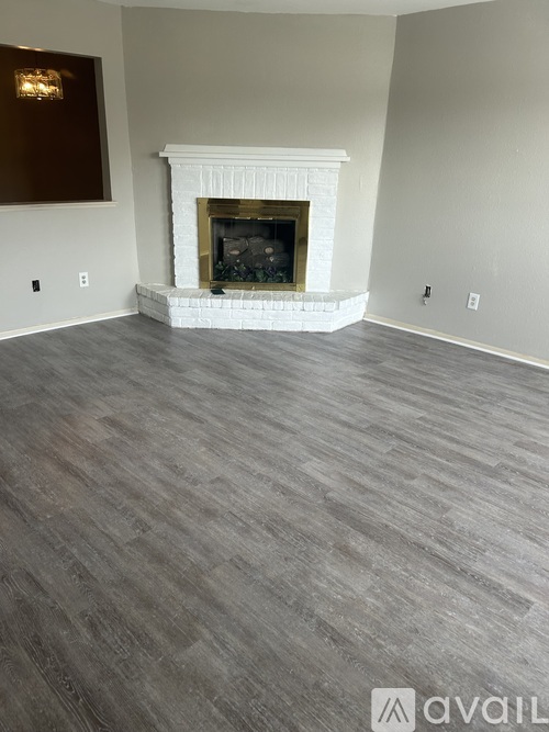 A living room with a fireplace and wood flooring.