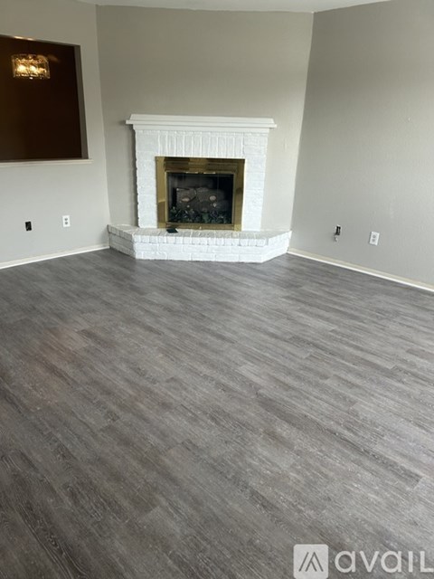 A living room with a fireplace and wood flooring.