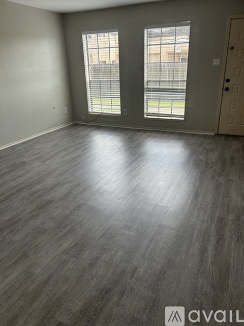 A room with wooden flooring and a sliding glass door.