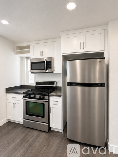 A modern kitchen with a stainless steel refrigerator and oven.