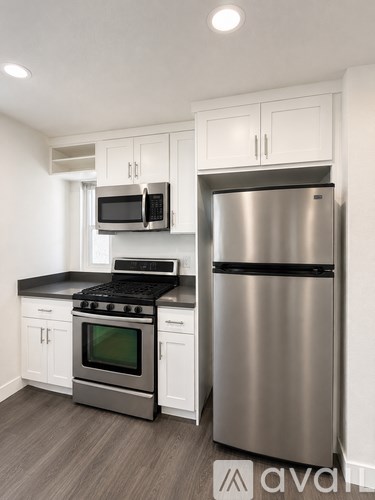 A modern kitchen with a stainless steel refrigerator and oven.