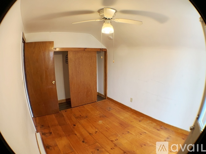 A room with wooden floors and a ceiling fan.