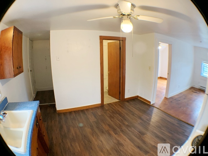 A room with wooden floors and a ceiling fan.