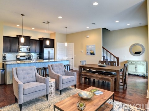 A modern kitchen with a dining area and a living room.