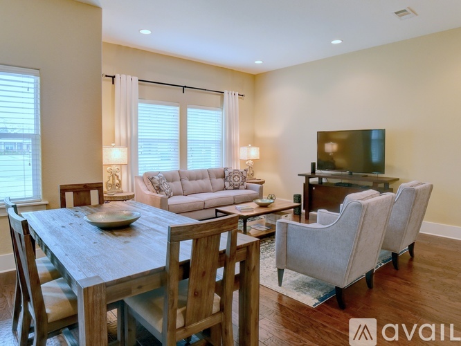 A modern dining room with a wooden table and chairs.