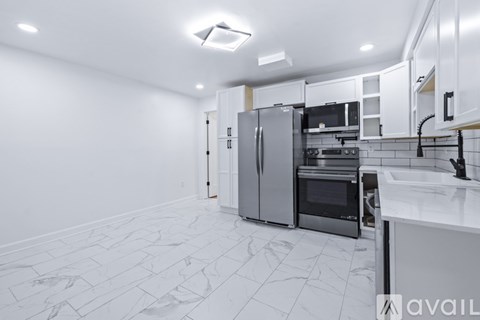 A kitchen with a refrigerator, oven, and sink.