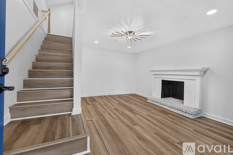 A living room with a fireplace and a staircase.