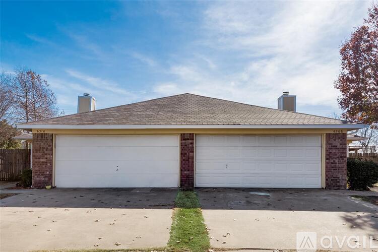 A two-car garage with a brick exterior and a white door.