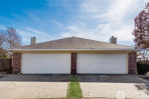 A two-car garage with a brick exterior and a white door.
