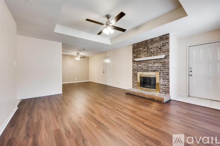 A room with a fireplace and wood flooring.