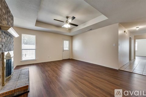 A spacious room with a ceiling fan and hardwood flooring.