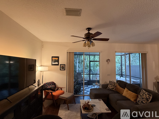 A living room with a couch, chair, and a ceiling fan.