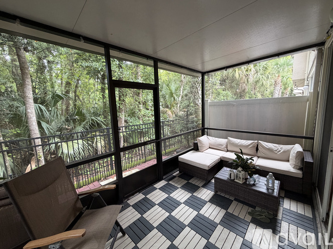 A balcony with a black and white checkered floor and a white sofa.
