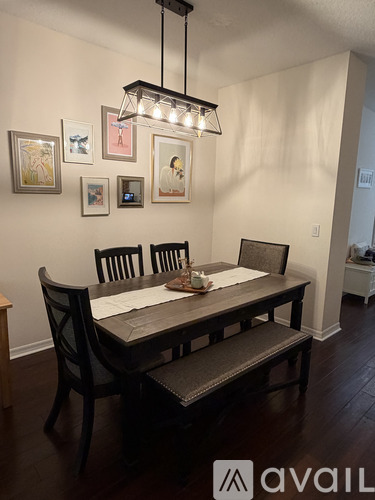 A dining room with a table and chairs and pictures on the wall.