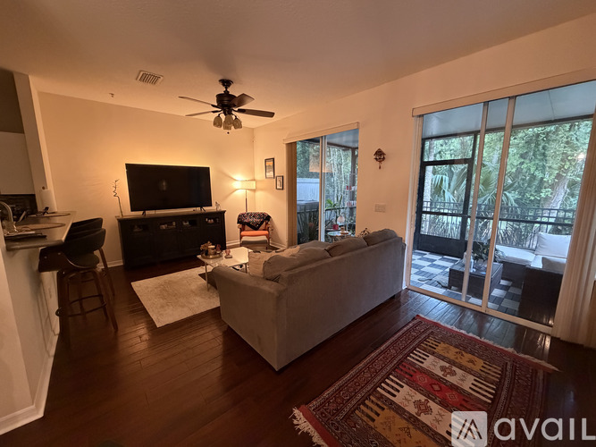 A living room with a couch, television, and sliding glass doors.