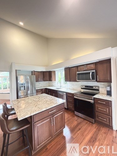 A kitchen with wooden cabinets and a granite countertop.