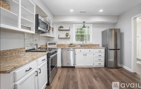 A kitchen with white cabinets and a granite countertop.