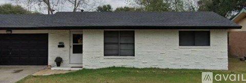 A white house with a black garage door is for sale.