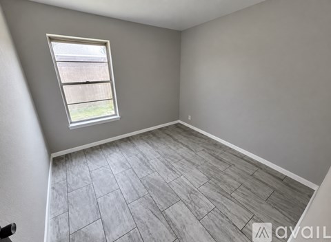 A room with a window and a tiled floor.