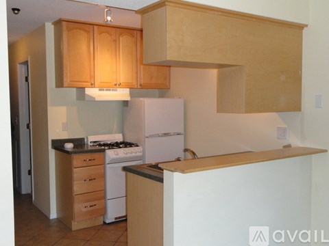A kitchen with wooden cabinets and a white refrigerator.