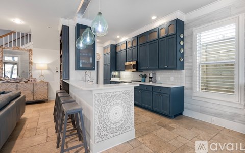 A kitchen with dark blue cabinets and a white patterned island.
