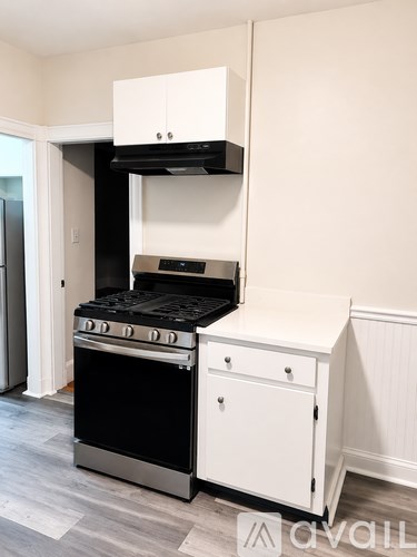 A black and white kitchen with a stove and oven built into a cabinet.