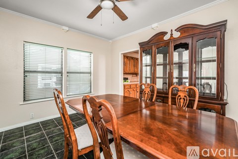 A dining room with a wooden table and chairs.