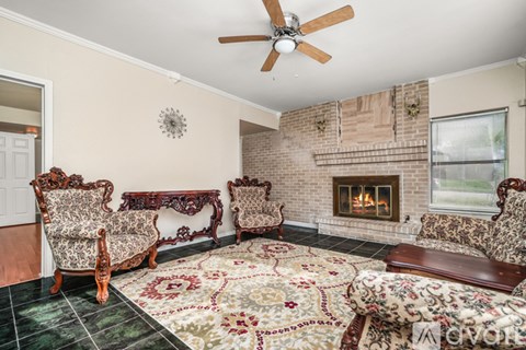 A living room with a fireplace and a rug.