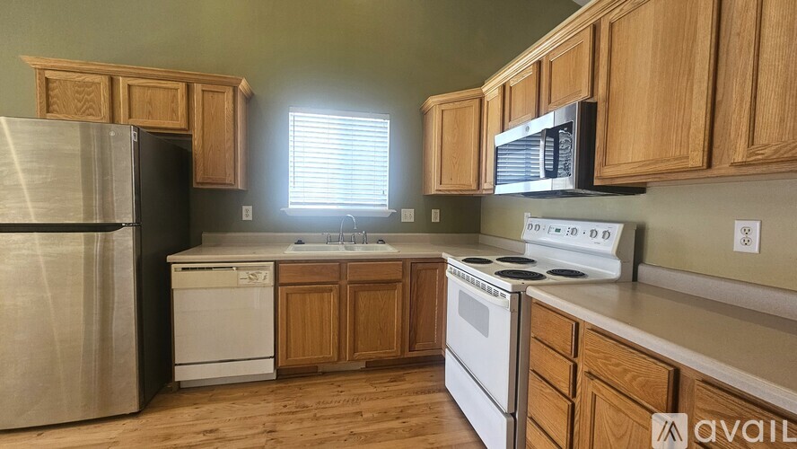 A kitchen with wooden cabinets and stainless steel appliances is available for rent.