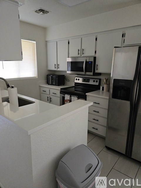 A kitchen with white cabinets and appliances.