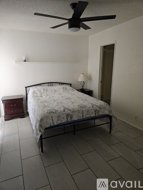 A bedroom with a bed, nightstand, and lamp.
