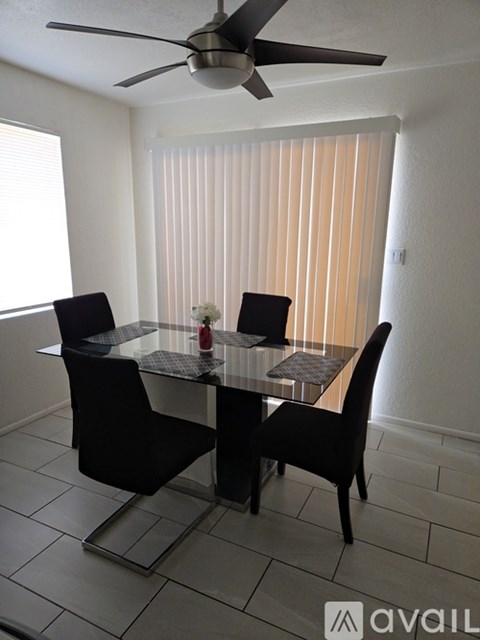 A dining room with a glass table and chairs.