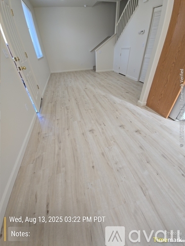 A room with wooden flooring and white walls.